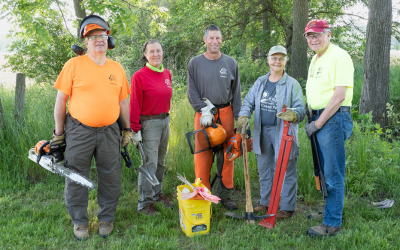 A group of volunteers with Anderson Park Friends standing with land management tools (chainsaw, etc.)