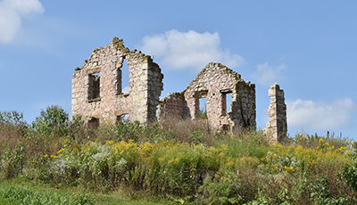 Stone ruins of the Matz farmstead surrounded by prairie in bloom
